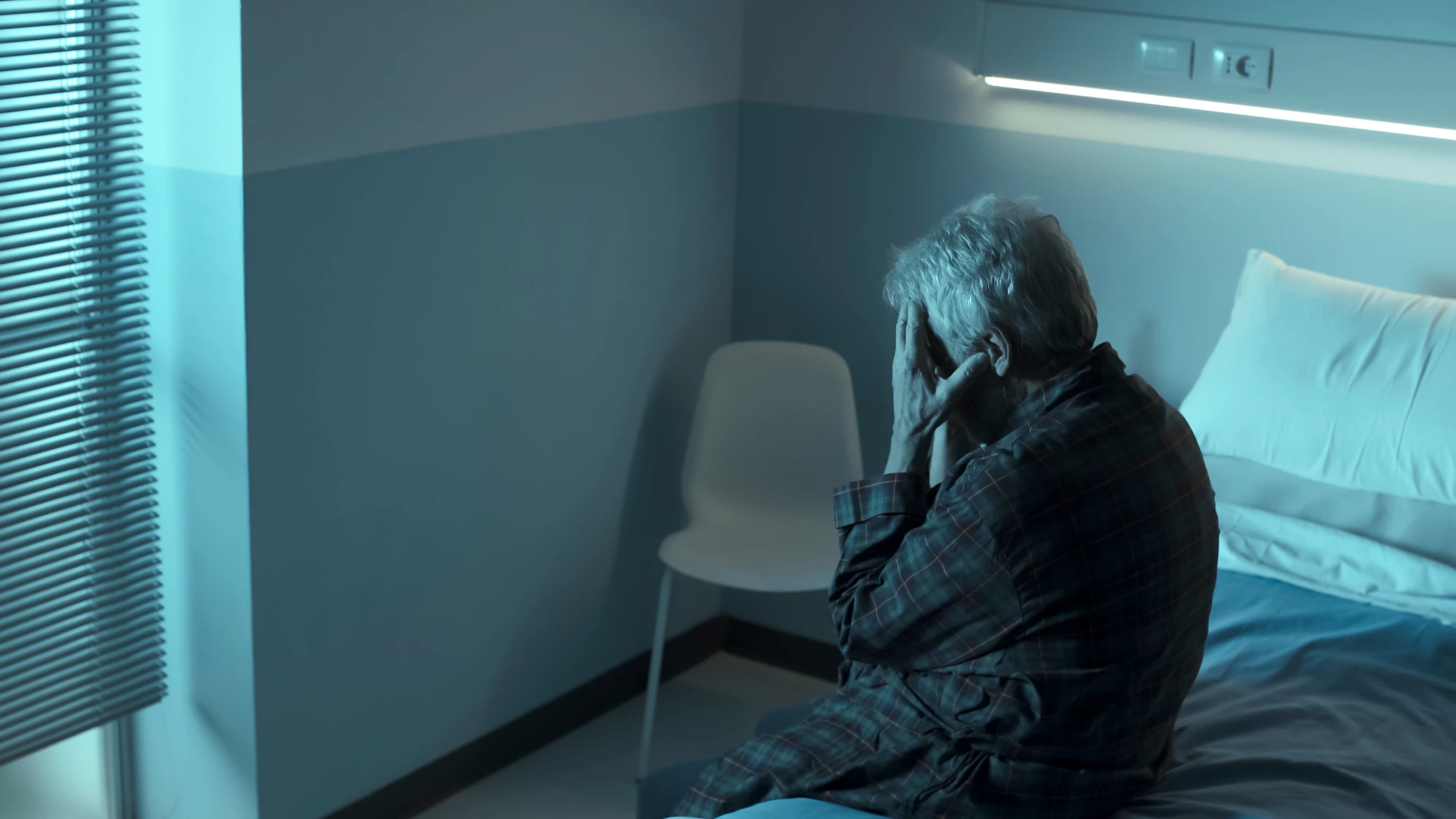 man not sleeping in hospital bed
