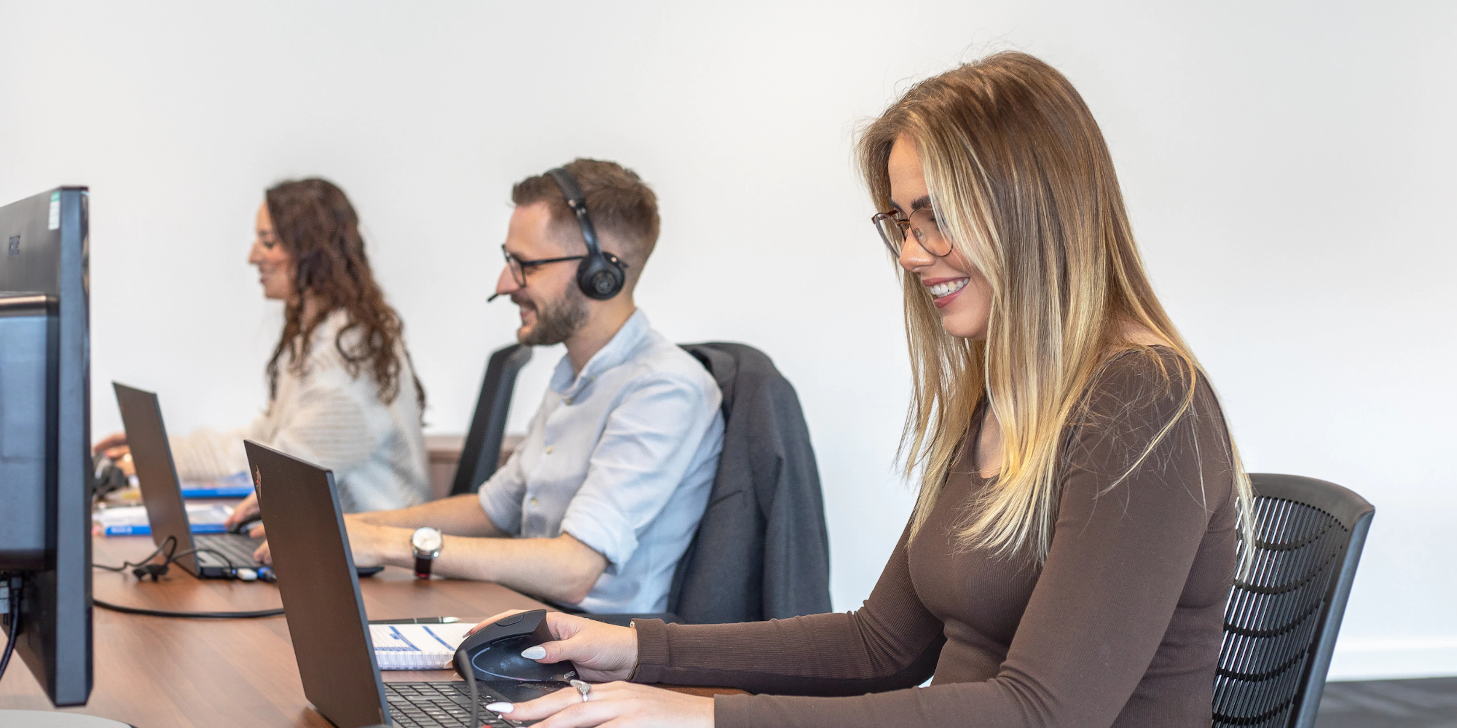 brymec team members on the phones and computers, smiling