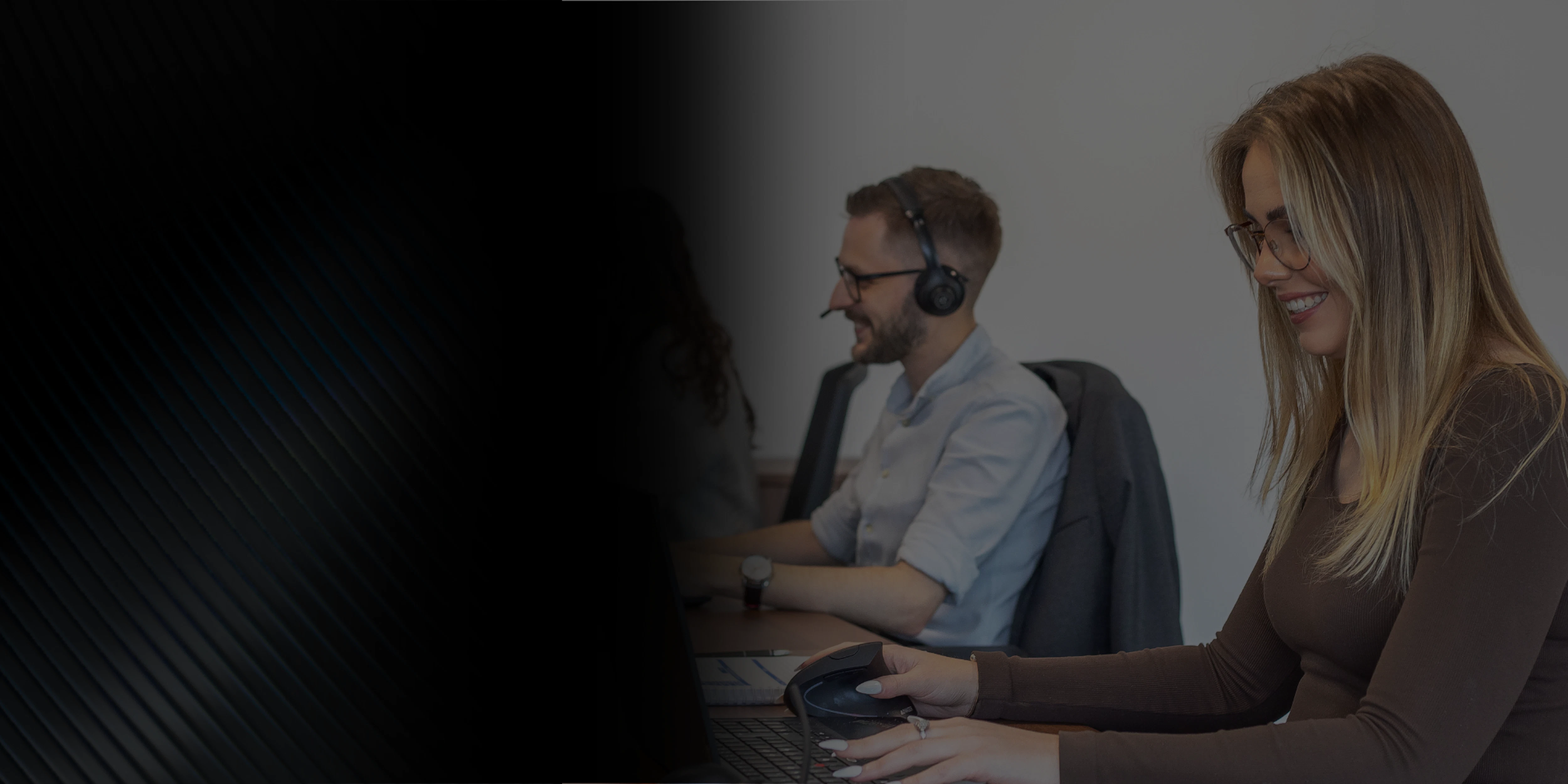 three brymec team members sat at a desk working on laptops
